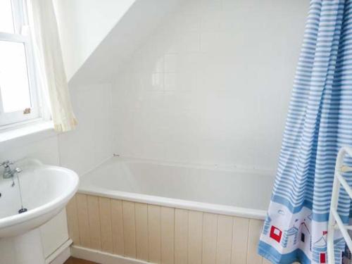 a white bathroom with a tub and a sink at 6 Knott in Flashader