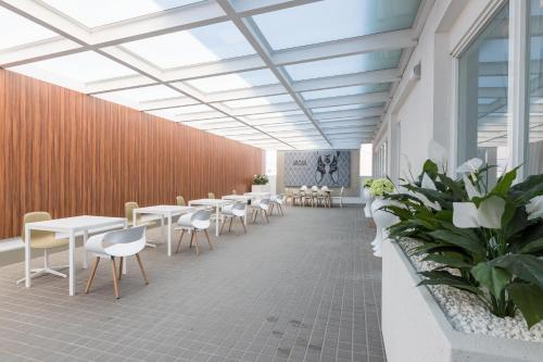 a cafeteria with tables and chairs and plants at Uya Motel in Xinwu