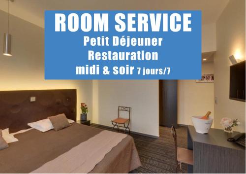 a room with a bed and a desk and a television at Le Vieux Beffroi in Béthune