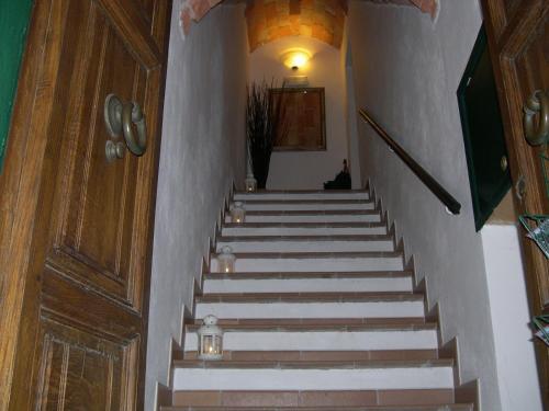 a stairway with a cat sitting at the bottom of the stairs at Locanda La Pieve B&B vicino Saturnia in Semproniano