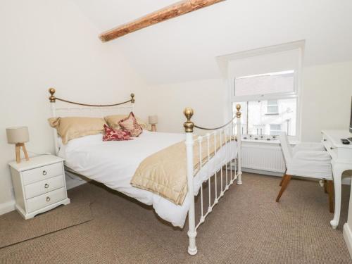 a bedroom with a white bed and a desk at 27 Borthyn in Ruthin