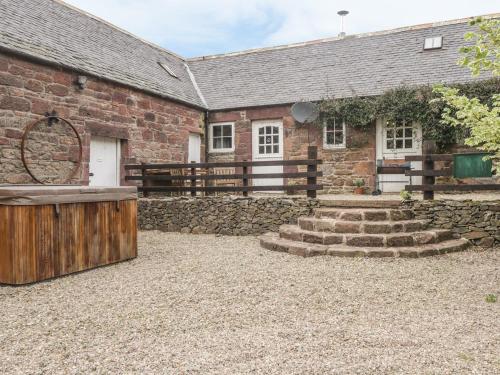 a stone building with a fence and stairs in front of it at Milltown House in Turriff