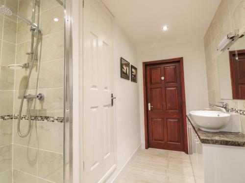 a bathroom with a shower and a sink and a toilet at Brunnion Cottage in Hayle
