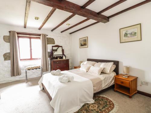 a bedroom with a large bed with white sheets at Brunnion Cottage in Hayle