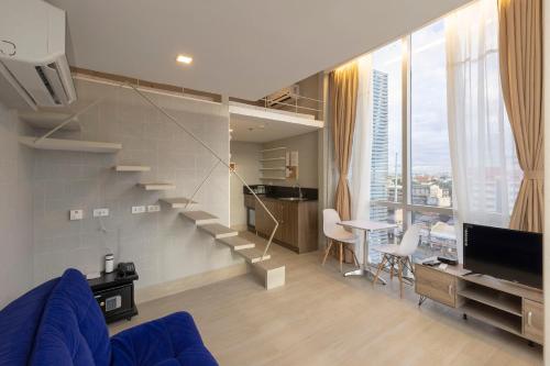 a living room with a spiral staircase and a dining room at Selah Pods Hotel Manila in Manila
