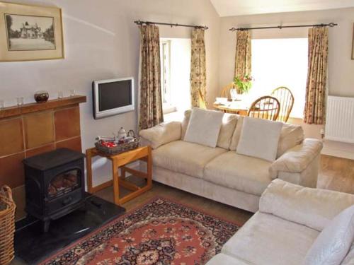 a living room with a couch and a fireplace at The Generals Cottage in Mitchel Troy