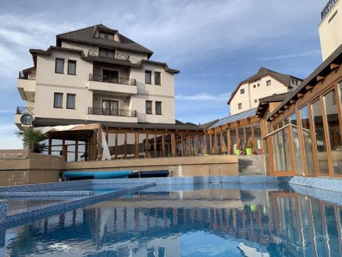 a hotel with a swimming pool in front of a building at Nana S44 Milmari Spa&Wellness in Kopaonik