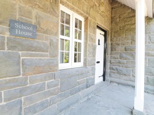 a brick building with a school house sign on it at School House in Builth Wells