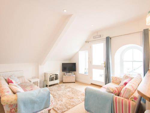 a living room with two couches and a tv at Spiral View in Perranporth