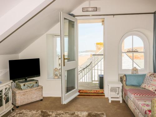a living room with a couch and a tv at Spiral View in Perranporth