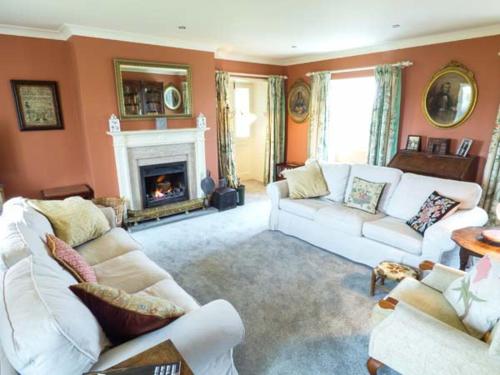 a living room with two white couches and a fireplace at The Old Forge in Waddington