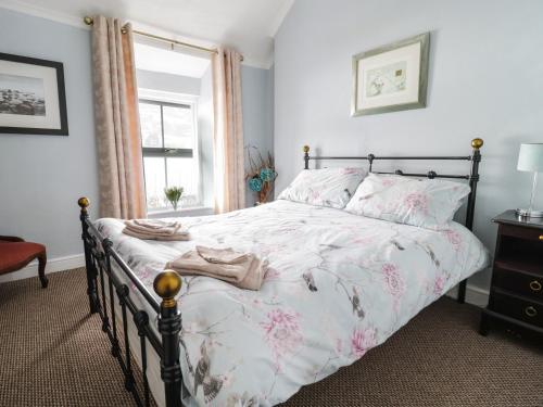 a bedroom with a bed with pink flowers on it at Preswylfa in Betws-y-coed