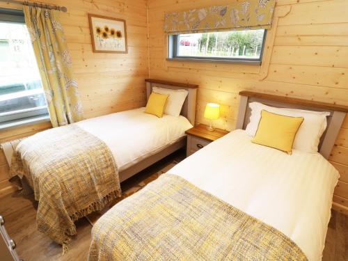 a bedroom with two beds in a log cabin at Elm Lodge in Ulverston
