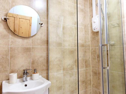 a bathroom with a shower and a sink and a mirror at The Old Sweet Shop in Par