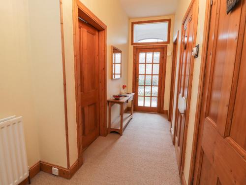 a hallway with a wooden door and a table at 63 Rosetta Road in Peebles