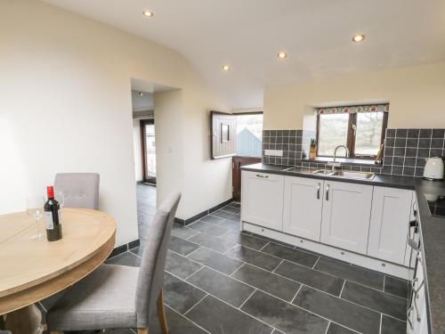 a kitchen with white cabinets and a table and a sink at Bothi in Bala