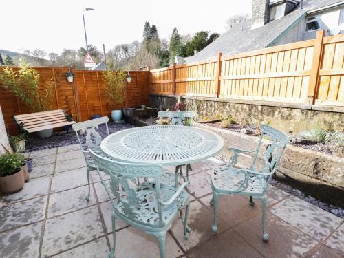 a patio with a table and chairs and a fence at Llwyn Onn in Dolwyddelan