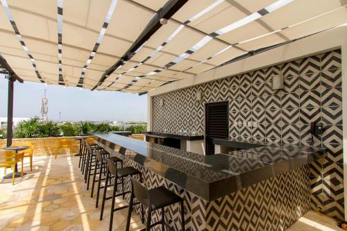 un bar en la azotea de un edificio con sillas en Lovely One Bedroom With Amazing Terrace View, en Playa del Carmen