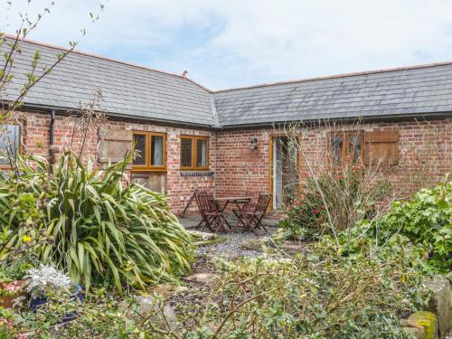a brick house with a garden in front of it at Acorn Cottage 2 in Petton