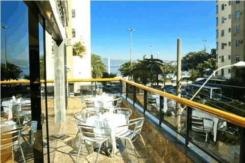 a balcony with tables and chairs on a building at Tower Icaraí Hotel in Niterói