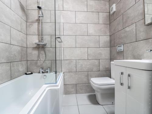 a bathroom with a tub and a toilet and a shower at The Stable in Berkeley