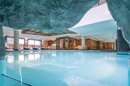 a large swimming pool with a rock ceiling at Le Kaïla in Méribel