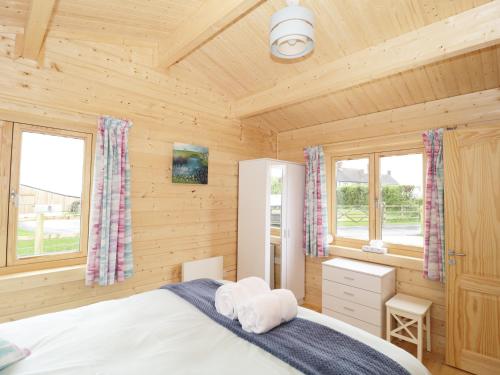 a bedroom with a bed in a wooden cabin at The Shippen in West Chinnock