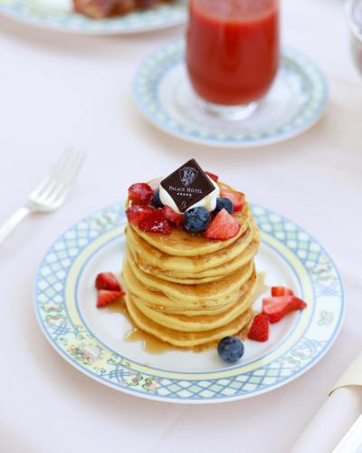 a plate with a stack of pancakes with strawberries and blueberries at Palace Hotel in Milano Marittima