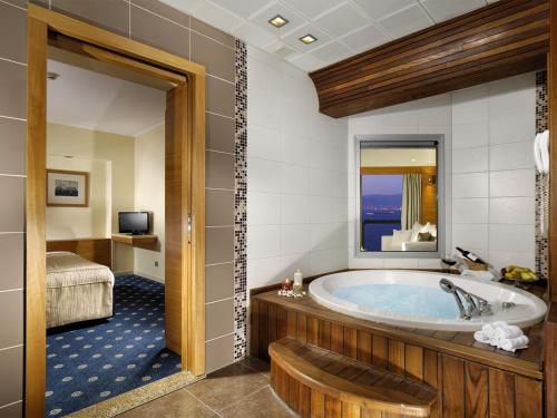 a bathroom with a tub and a bedroom at Best Western Plus Hotel Konak in Izmir