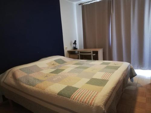 ein Schlafzimmer mit einem Bett mit einer Decke darauf in der Unterkunft Vabaduse Apartment in Kärdla