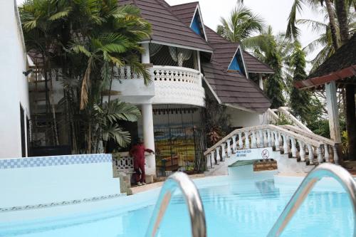 蒙巴薩的住宿－A wonderful Beach property in Diani Beach Kenyaa dream holiday place，一个带游泳池和房子的度假胜地