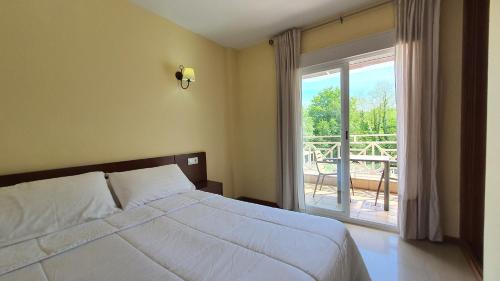 a bedroom with a bed and a large window at Sun Galicia Hotel y Apartamentos in Sanxenxo