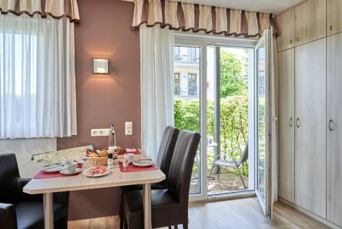 uma sala de jantar com mesa e cadeiras em Haus Seemuschel _ Fewo 4 em Cuxhaven