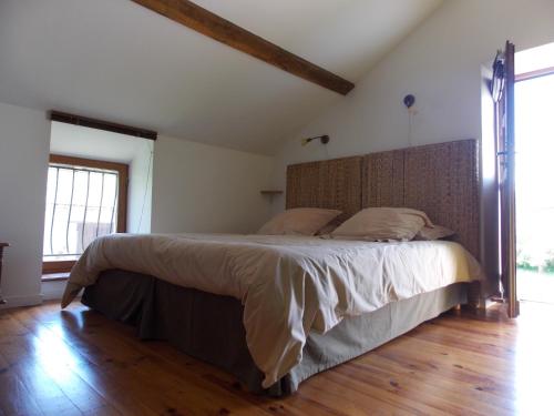 a bedroom with a large bed with a wooden headboard at côté jardin in Saint-Clément