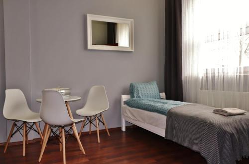 1 dormitorio con 1 cama, mesa y sillas en Teatr Baj Pomorski, en Toruń