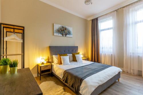 a bedroom with a large bed and a table at Cosy & Quiet Hideout in Cluj-Napoca