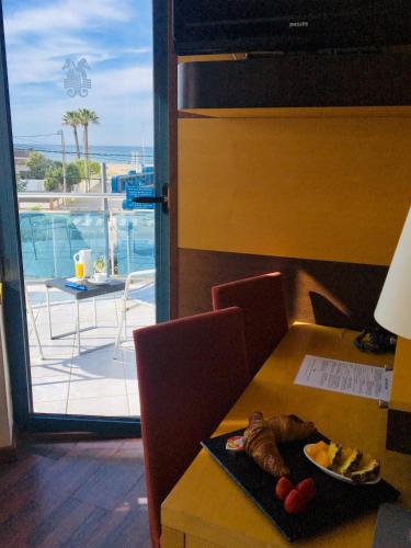 a table with a plate of food and a view of the ocean at Best Western Hotel Mediterraneo in Castelldefels