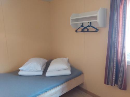 a room with a bed with two pillows and a window at Magalaupe Camping in Oppdal