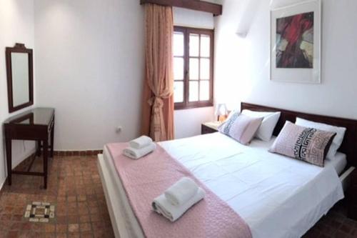 a bedroom with a bed with two towels on it at Pyrgi Spetses in Spetses