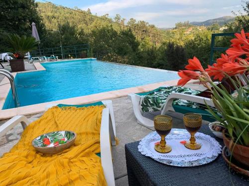 a table and chairs next to a swimming pool at Quinta Paraíso do Ermal in Vieira do Minho