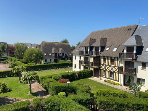 an apartment building in a village with a garden at Escapade à Cabourg, 300M plage, calme et chaleureux in Cabourg