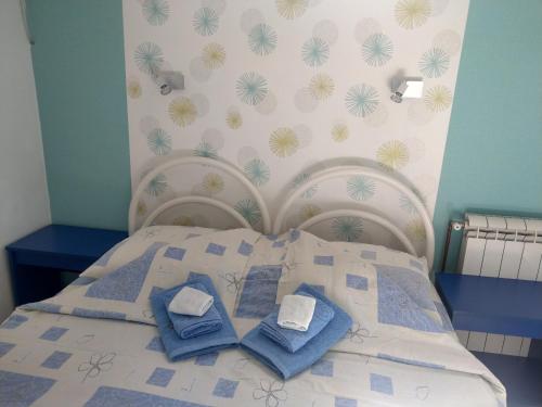 a bed with blue pillows on it in a bedroom at Apartment Harmonija apatin in Apatin