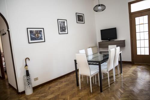 a dining room with a black table and white chairs at Tiberim Apartment Trastevere 9 in Rome