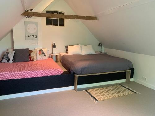 a bedroom with two beds in a attic at Uitzicht op de haven in Kollum