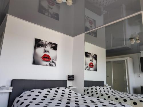 een slaapkamer met een zwart-wit bed en foto's aan de muur bij Clubber Naturiste Design in Cap d'Agde