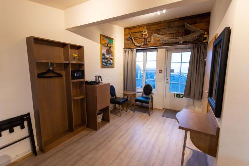 a living room with a desk and a table and chairs at Hlid Fisherman's Village in Álftanes