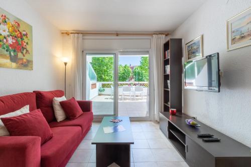 エンプリアブラバにあるApart-rent Apartment Sant Mori 0187のリビングルーム(赤いソファ、テレビ付)