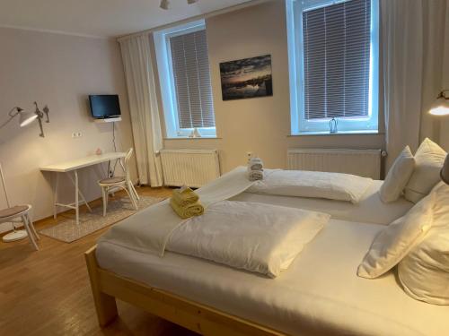 two beds in a bedroom with two windows at Hotel-Pension Mandy - Adults Only in Senftenberg