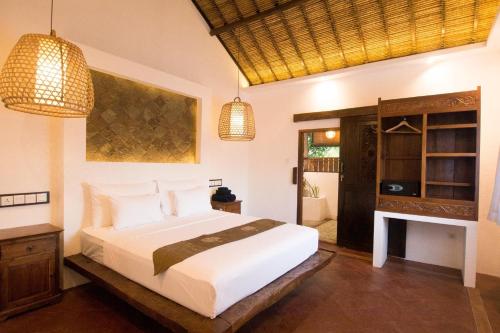 
a bedroom with a large bed and a large window at Mandana Spanish Villa and Tapas Café Gili Air in Gili Islands

