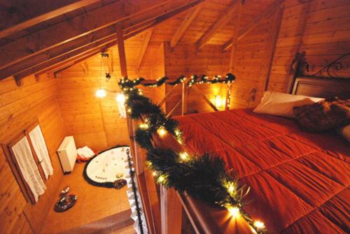a bedroom with a bed with christmas lights and a table at Guesthouse Alonistaina in Alonistaina